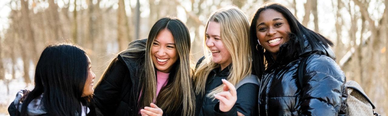 Four girls laughing and posing for a photo